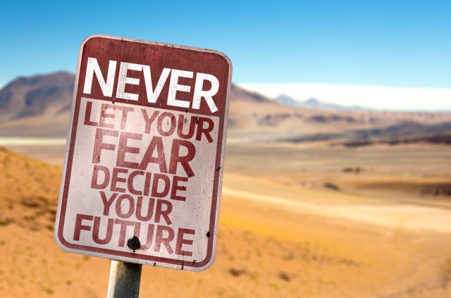 Never Let Your Fear Decide your Future sign with a desert backgr